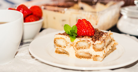 Homemade tiramisu cake decorated with strawberries Italian cuisine, Selective focus
