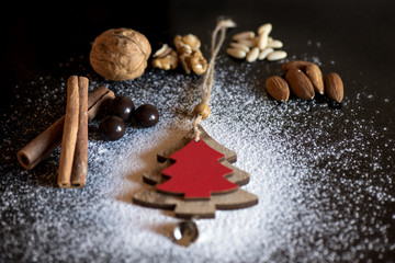 Fototapeta na wymiar Christmas Decoration and walnuts, almonds, pine nuts, cinnamon, chocolate