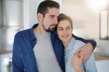 Middle-aged couple standing together in home kitchen