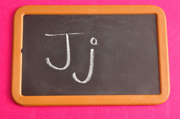 A black board with the alphabet letter J in a capital and small letter