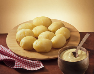 wooden plate of boiled potatoes and mayonnaise
