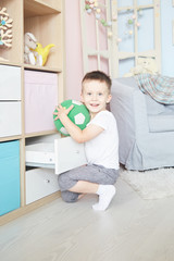 Full length portrait of a child with a soccer ball isolated in home