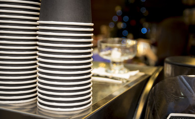 stack of a paper cups  for take out in  coffee shop on the top of the coffee machine