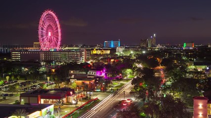 Orlando FL International Drive Timelapse at Night with Colorful Big Wheel Attraction and Cars Driving along the Popular Stretch of Road lined with Restaurants Hotels and Attractions