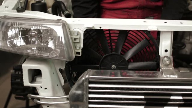 The mechanic works on rebuilding of sport rally car.