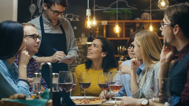 In the Bar/ Restaurant Waiter Takes Order From a Diverse Group of Friends. Beautiful People Drink Wine and Have Good Time in this Stylish Place. Shot on RED EPIC-W 8K Helium Cinema Camera.