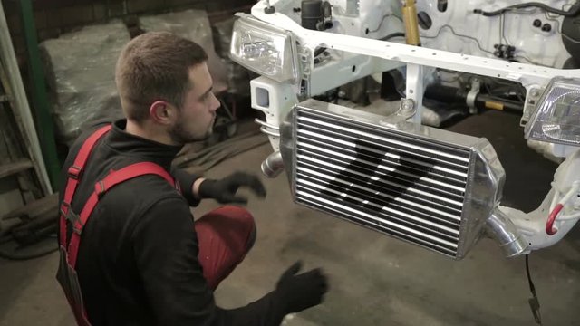 The mechanic works on rebuilding of sport rally car.