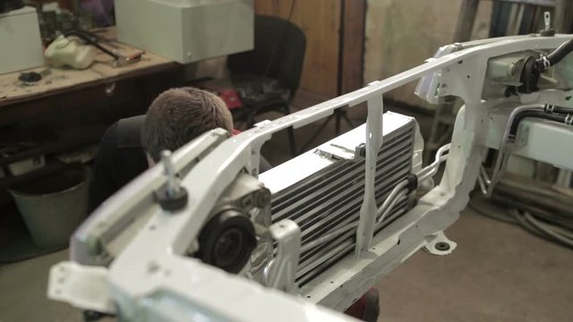 The mechanic works on rebuilding of sport rally car.