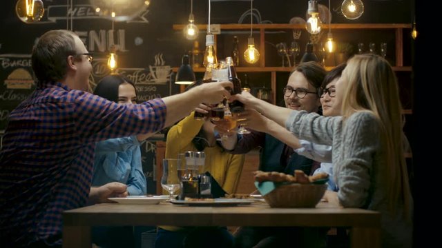 Diverse Group of Friends Celebrate with a Toast and Clink Raised Glasses with Various Drinks in Celebration. Shot on RED EPIC-W 8K Helium Cinema Camera.