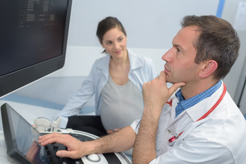 pregnant woman and doctor checking the ultrasound scan