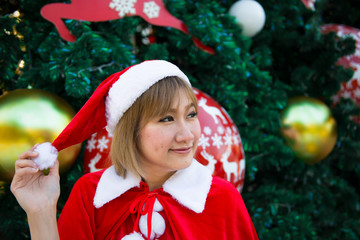 Beautiful young asian woman in Santa Claus clothes outdoors,Thailand people,Sent happiness for children,Merry christmas,Welcome to winter,Decorated christmas background