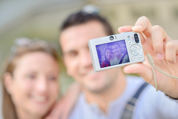 Couple taking photo of themselves with digital camera