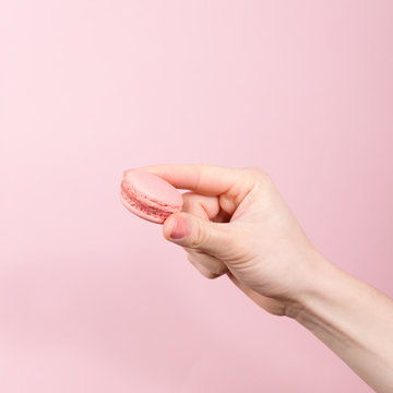 Hand holding pink macaroon