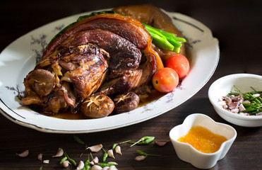 Stewed pork leg in white dish on wooden background with dim light  Asia food