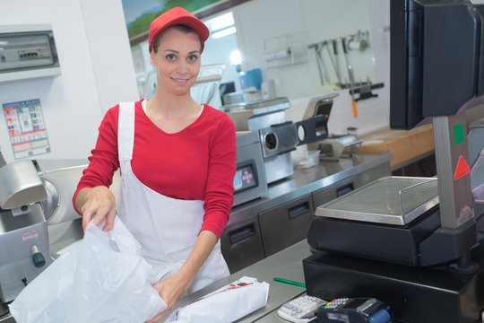 confident female butcher working in store