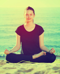 Girl in black T-shirt is sitting and doing meditation