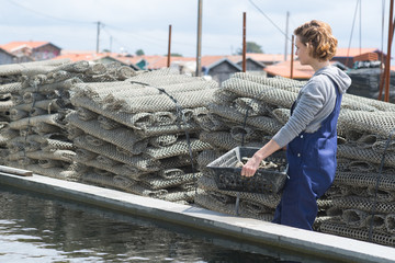 woman carrying basket of oysters