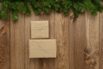 Caja de regalos sobre fondo de madera y guirnalda verde