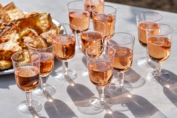 Refreshing pink wine in a glass with cakes on a table, against the background of a vineyard. the concept of winemaking.
