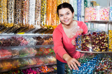 Girl choosing sweets in shop