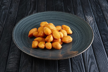 Portion of fried potato balls on dark wooden table