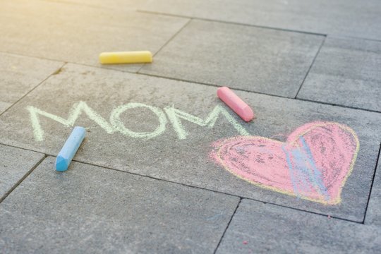 Love Mom. Children's drawing colored crayons on the asphalt