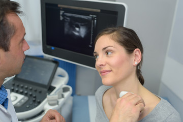 woman getting an ultrasound scan on neck by doctor - obrazy, fototapety, plakaty