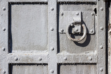 Old metal door close-up with round handle