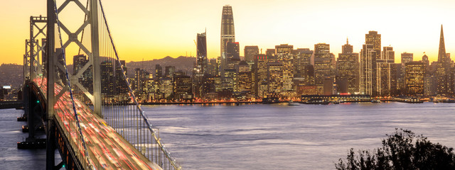 San Francisco Downtown and Bay Bridge in the golden hours. Panoramic view of San Francisco water...
