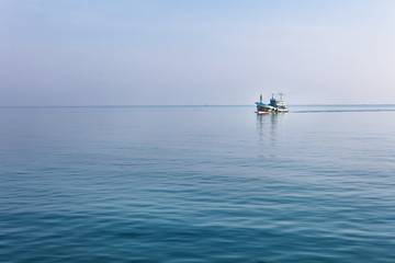 Obraz premium Lonely boat at Andaman blue sea in calm weather, Thailand