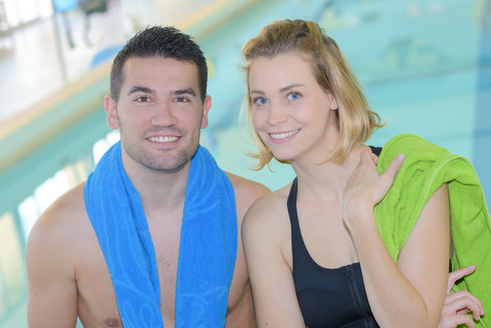 couple posing next to a swimming pool