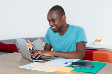 Afrikanischer Mann arbeitet am Laptop
