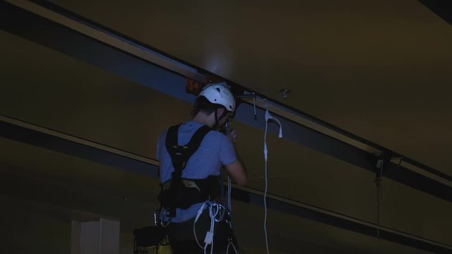 Industrial climber mounts Christmas decorations in the unsupported space in the shopping center