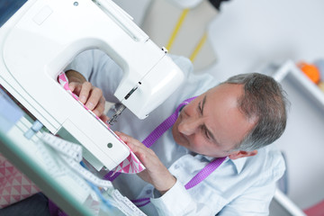 Fototapeta premium mature tailor working at sewing machine