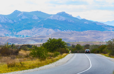 landscape with mountains, road and car