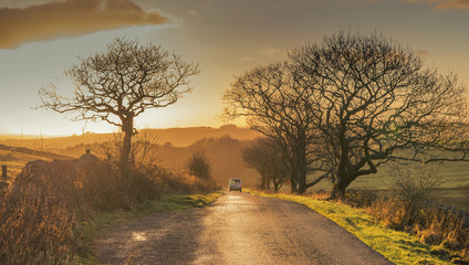 Fototapeta na wymiar A car on a road in a sunset atmosphere, UK