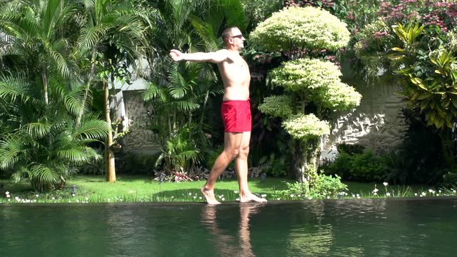 Satisfied man walking to the pond and relaxing, steadycam shot, slow motion shot at 240fps
