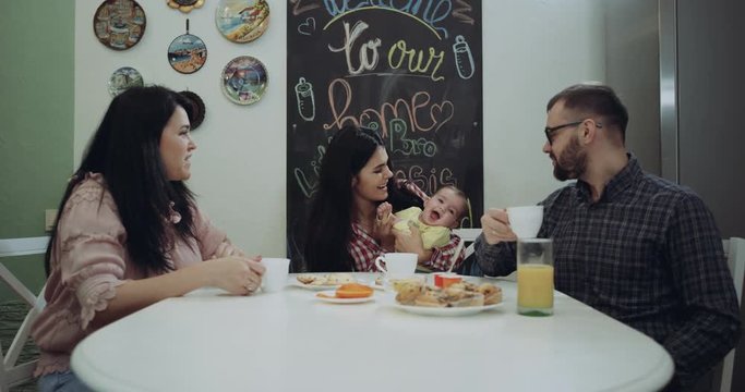 Happy family in the morning taking the breakfast and playing with a baby boy. red epic