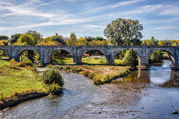 Fototapeta na wymiar Bridge leading into an old medieval town under blue skies with f
