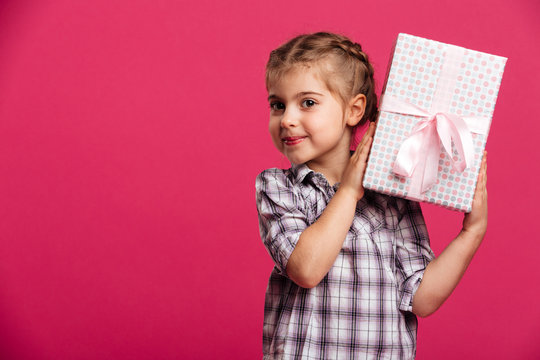 Happy little girl child holding gift box surprise.