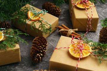 Craft Paper Presents Boxes Cord Fir Tree Branch Dry Sliced Orange Fruit on Concrete Background. Christmas Gift Concept Top View. Analog Camera Antique Toned Image. New Year Preparation Background. 