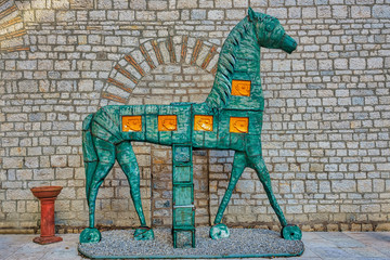 A historic horse figure in front of a medieval wall