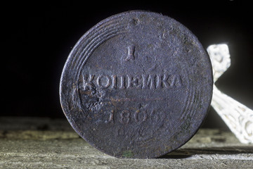 An old coin of the Russian Empire of 1805 on the blurred background of the Orthodox cross