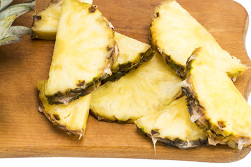 Ripe pineapple and pineapple slices on a wooden background tropical fruits