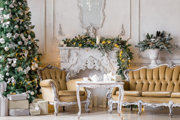 Christmas morning . classic apartments with a white fireplace, decorated fir tree, sofa, large windows and chandelier.