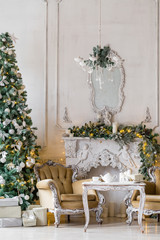Christmas morning . classic apartments with a white fireplace, decorated fir tree, sofa, large windows and chandelier.