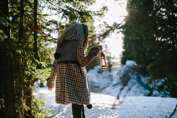 Portrait of woman Holding flashlight in magic forest in winter