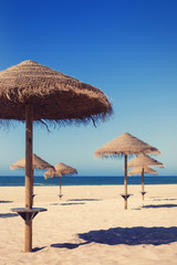 Beach umbrellas near blue ocean. Summer travel, vacation on sea shore