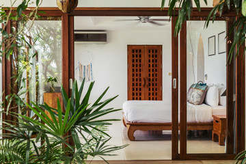 Modern bed room interior in Luxury villa. White colours, glass wall, tropical style