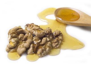honey on dry walnut and beside wooden spoon